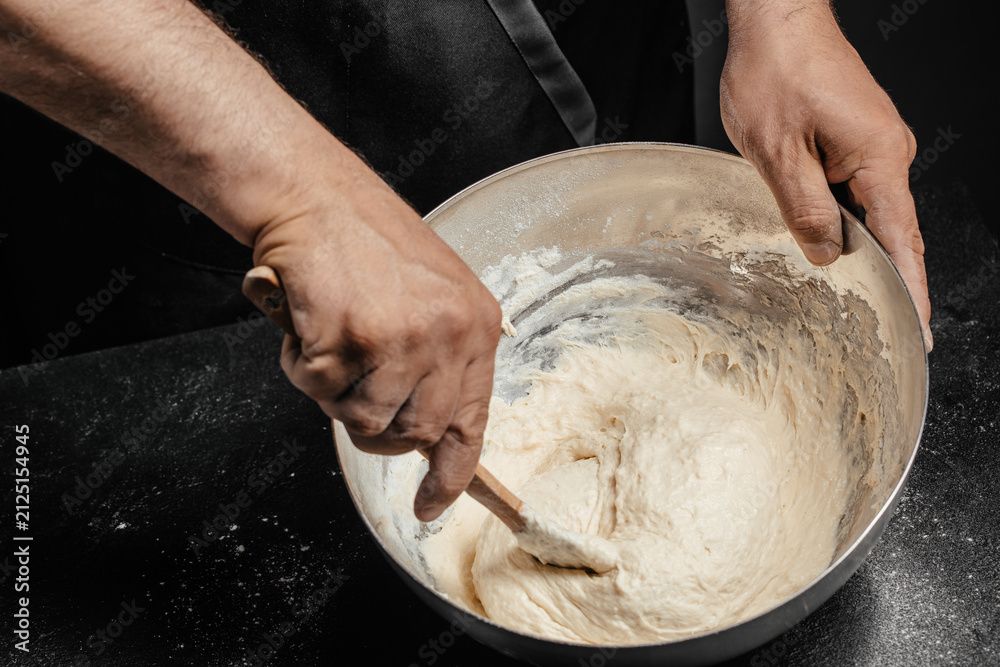 Fototapeta premium Mixing Bread Dough by Hand in Metal Bowl