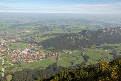 Fotografie Town fields and roads spread across a green alpine valley