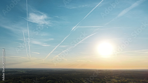 Foto Multiple airplane vapor trails stretching across morning sky