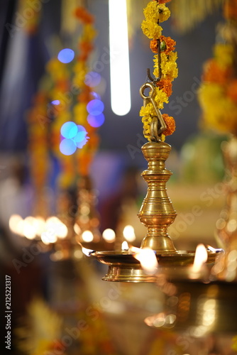 Fotografie Traditional South Indian brass oil lamp Nilavilakku with lit flame and glowing w
