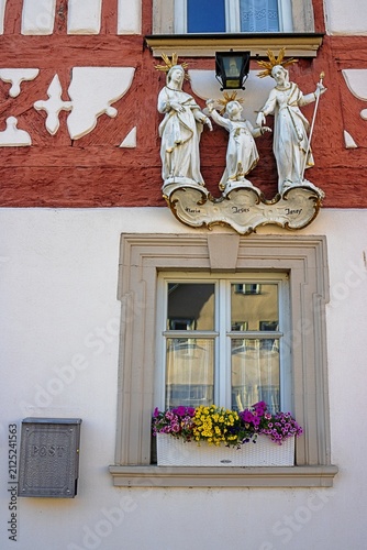 haßfurt, deutschland - schönes blumenfenster mit drei statuen