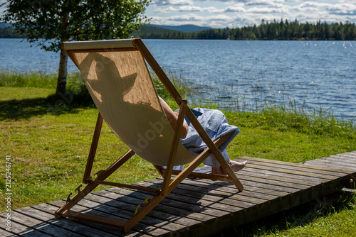 Woman relaxing on the wooden chair on the beach