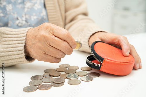 Quadro su tela Asian senior or elderly old lady woman holding counting coin money in purse
