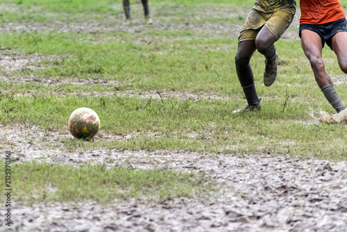Two boys are running to get the soccer ball