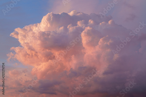 Cloudscape with pink fluffy clouds in sunset sky