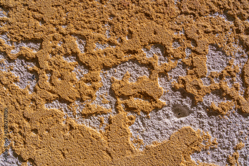 The plastered wall of an old yellow building can be used as a textured background.