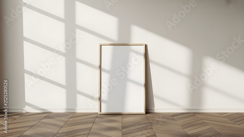Minimalist interior featuring a blank vertical wooden picture frame leaning against a plain wall on a herringbone parquet floor, soft natural sunlight
