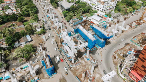 Foto Metro rail construction over a city road with piers and blue barriers below