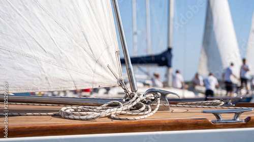 Sailboat deck with coiled rope and cleat during regatta