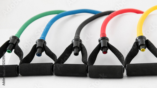 Set of colorful resistance bands with foam handles on white background
