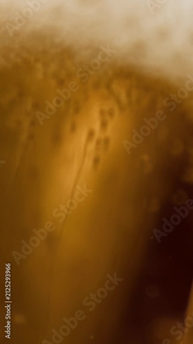 Cinematic slow-motion pouring shot of golden craft beer filling a glass, with creamy foam, sparkling carbonation and rich amber tones. Premium microbrewery IPA and lager aesthetic for brewing.