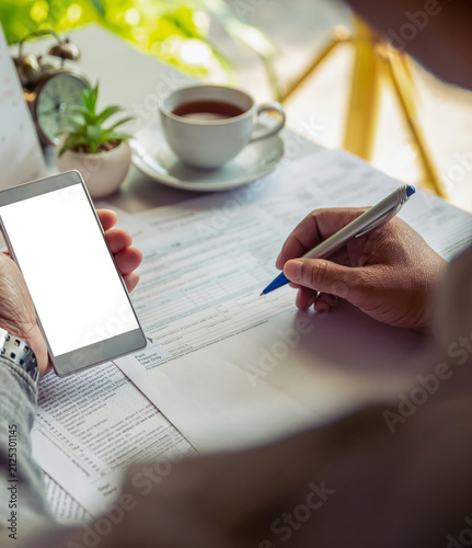 Budget and Tax planning concept. Accountant hand using calculator and review tax forms. Represents personal finance, tax preparation, budgeting, and season to pay tax-vertical image