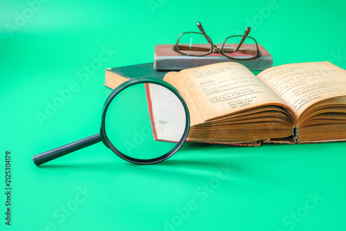 A magnifying glass and Old English book , textbook for learning language.
