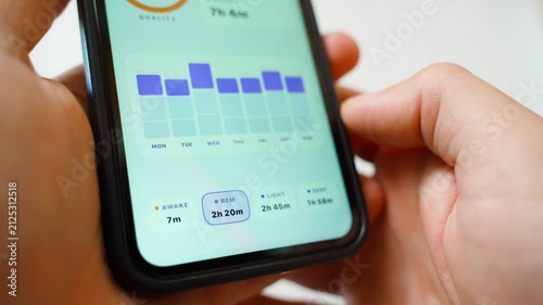 Hand holding smartphone analyzing sleep phases in tracking app close-up 