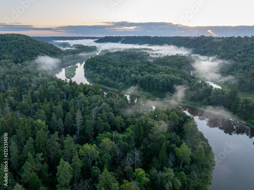 Photography Aerial panorama of the misty Gauja Valley at sunrise with the Sigulda bobsleigh