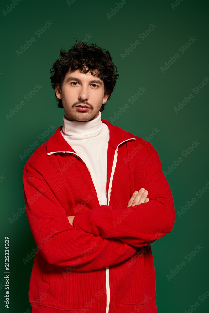 Obraz premium Young man with stylish moustache showcases a striking fashion statement on a vibrant backdrop