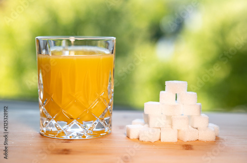 Canvastavla Glass orange juice and a stack of sugar cubes