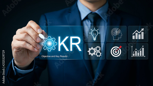 Businessman writing KR Objective and Key Results with digital icons on a screen strategy