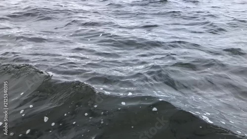 sea waves near the side of a moving fishing boat