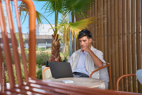 Young man concentrating on laptop during remote work