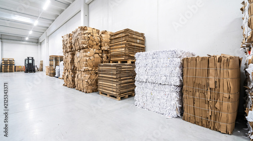 Bales of compressed cardboard and paper waste in a recycling warehouse