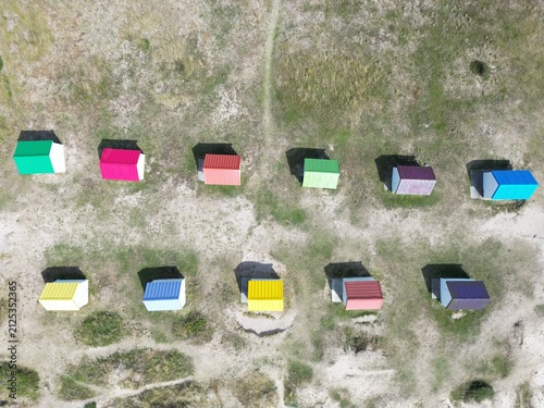 Aerial view of the iconic colorful beach huts lined up on the sandy dunes in Gouville-sur-Mer, Normandy, France.