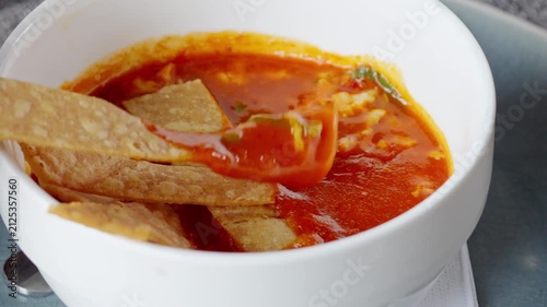 Dipping a crunchy tortilla chip in hot mexican tortilla soup