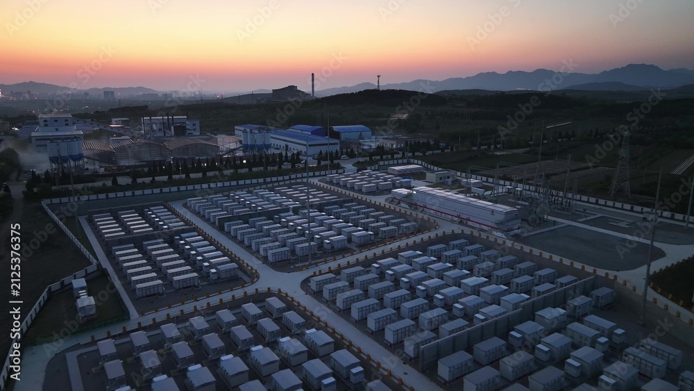 Fototapeta premium Large-scale energy storage power station at sunset with battery arrays and industrial facilities