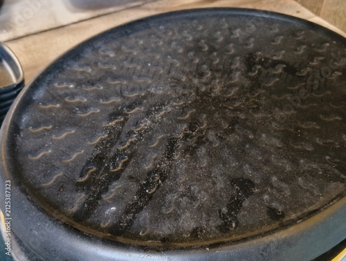 Canvas Print Textured round black non-stick grill pan or griddle surface