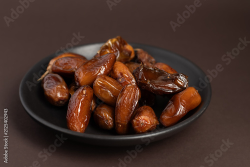 Premium Dates on Black Plate with Brown Background
