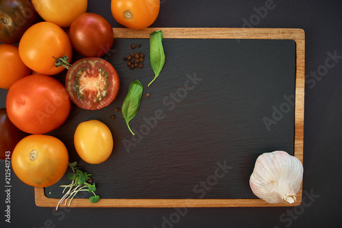 Vegetables dark background with copy space. Healthy meal. Menu, price background. Tomatoes on black chalkboard.