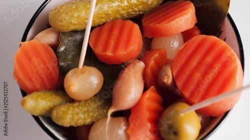 Assorted pickled vegetables with carrots, gherkins, onions and olives in a bowl. Traditional appetizer. High quality 4k footage