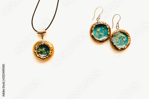 Jewelry made of ceramics. Ceramic earrings and pendant. Turquoise earrings on a white background. Handmade jewelry on a white background.