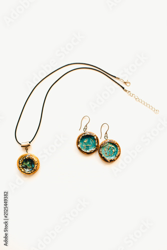 Jewelry made of ceramics. Ceramic earrings and pendant. Turquoise earrings on a white background. Handmade jewelry on a white background.