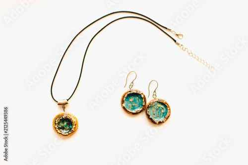 Jewelry made of ceramics. Ceramic earrings and pendant. Turquoise earrings on a white background. Handmade jewelry on a white background.