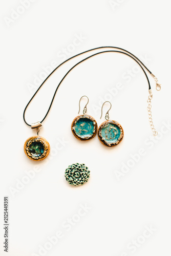 Jewelry made of ceramics. Ceramic earrings and pendant. Turquoise earrings on a white background. Handmade jewelry on a white background.