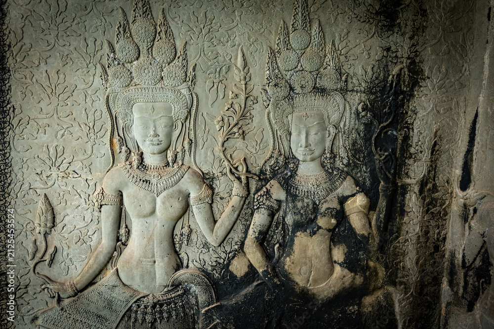 Fototapeta premium Ancient stone carving of a female Apsara dancer inside Angkor Wat temple in Siem Reap, Cambodia