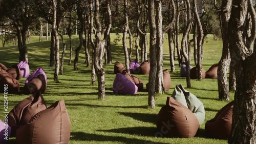 Relaxation area with soft seats located on the lawn among the trees in the park