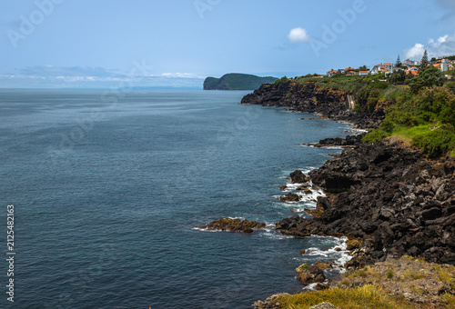 View of Ilhéu de Cabras from Cruz do Canário viewpoint on Terceira Island, Azores, Portugal, featuring two volcanic islets rising from the Atlantic Ocean under a calm blue sky