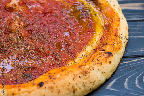 The gluten-free pizza has a thick crust with red sauce on top.