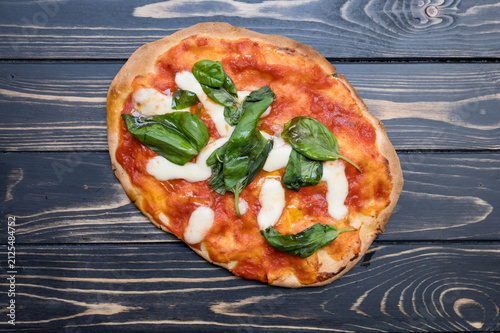 A glutenfree pinsa with tomato sauce and spinach on a table.