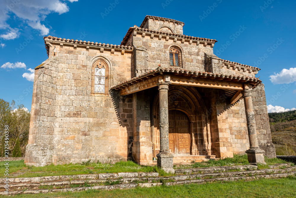 Obraz premium Exterior view of the 16th century Gothic church of San Martin de Tours, preserving a 12th century Romanesque bell tower, featuring a stone porch and pointed arch entrance, in Jaramillo Quemado, Burgos