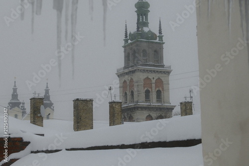 Canvastavla Heavy snow covers the historic rooftops and the tall Korniakt Tower in Lviv on a
