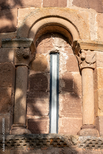 Konstfotografi 12th century Romanesque apsidal window with round arch, carved capitals, and col