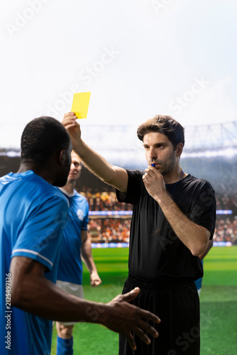 Fotografía Referee blows the whistle and shows a yellow card toward a protesting player, issuing a disciplinary warning for a rules violation during a tense football match and dispute on the pitch