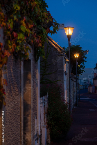 Quiet evening street scene with warm lamp glow in a quaint village setting