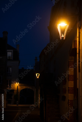 Quiet night in a charming narrow alley illuminated by warm streetlights