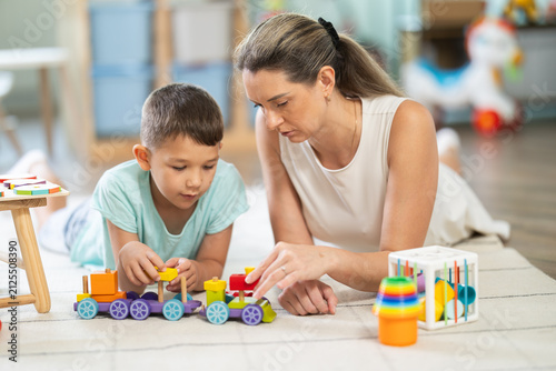 Photography Individual activity for children, child plays with wooden train constructor, connects parts of train