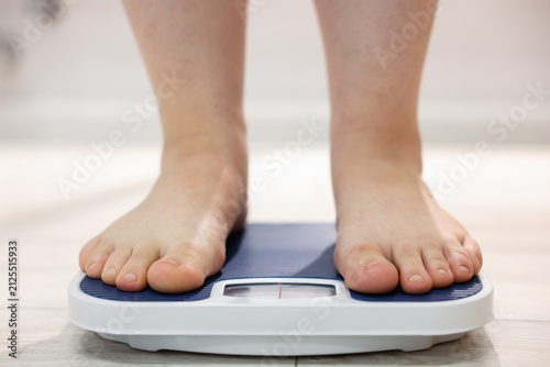 Fotografie Overweight woman on scale at home, closeup
