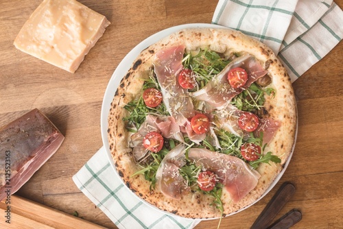Obraz na plátně Traditional Italian pizza preparation featuring thin crust dough topped with sal